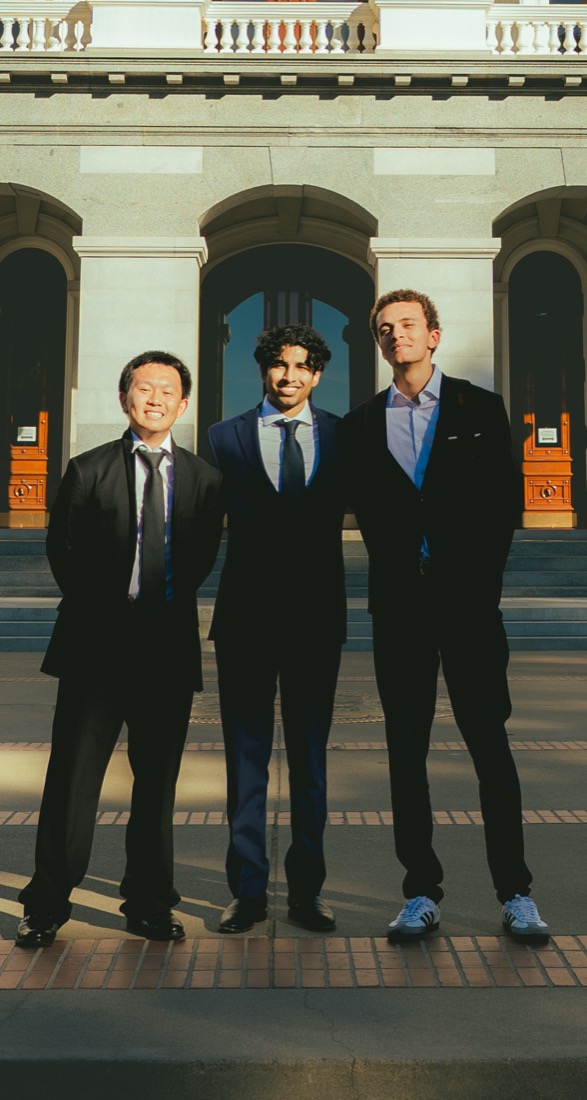 Three fellows in dark suits standing together outside the California State Capitol